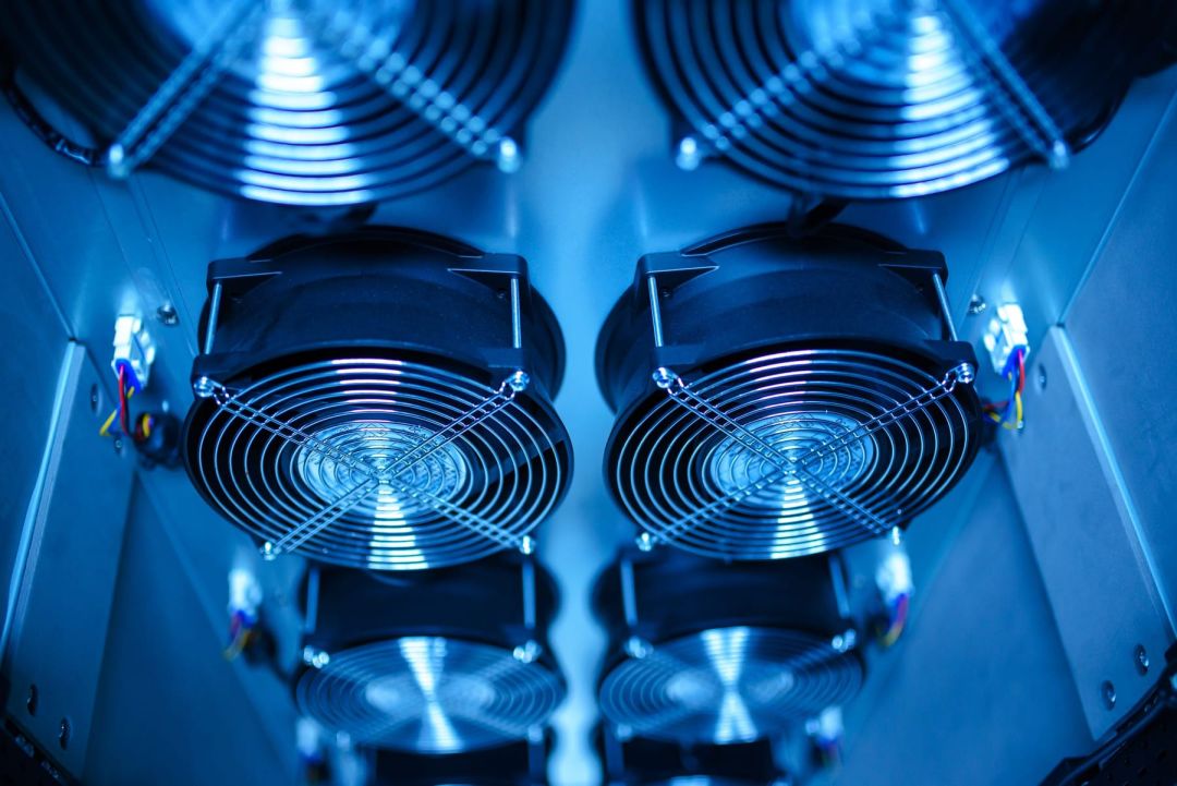 Blau beleuchtete Lüftereinheiten in einem Technikschrank, frontal und symmetrisch fotografiert